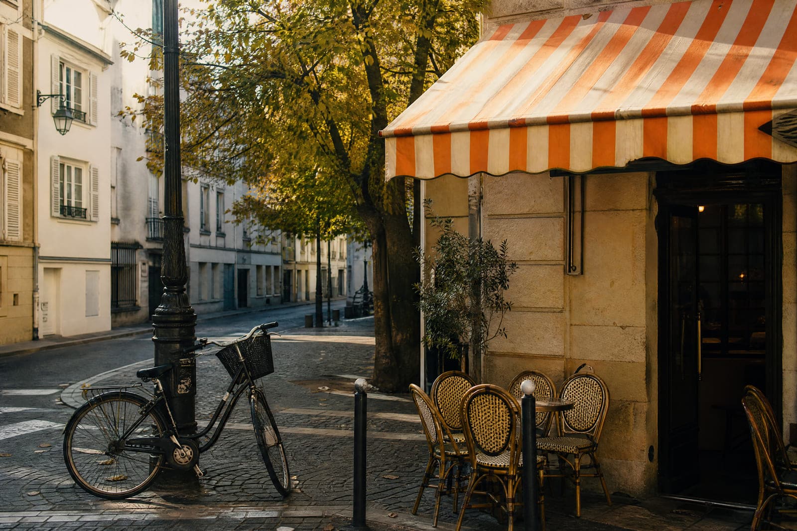 Photograph of a street corner with a bicycle and a cafe awning